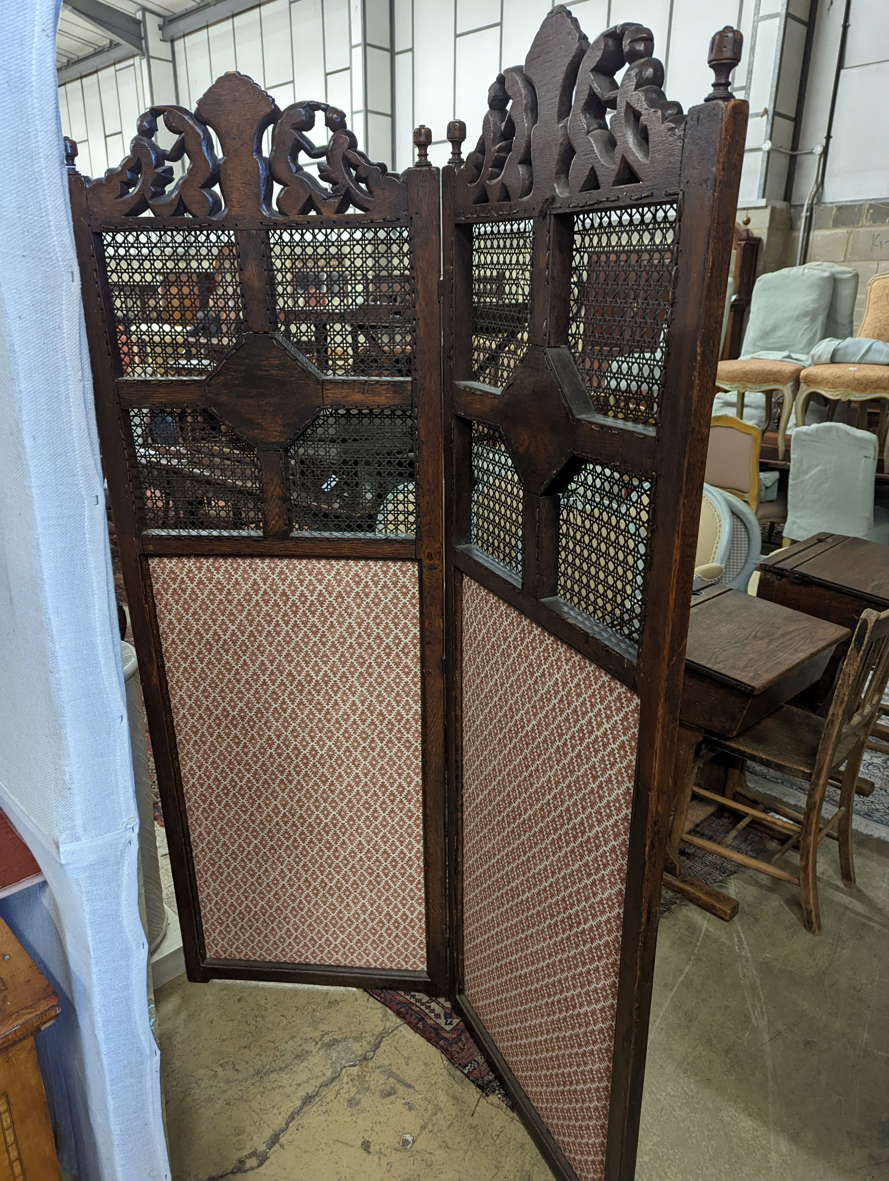 A 1920's Carolean style oak and cane work two fold dressing screen, each panel width 60cm, height 182cm